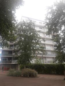 apartamentowiec z drzewem przed nim w obiekcie Residence d'Anjou - Grand studio avec balcon et parking privatif w Perpignanie