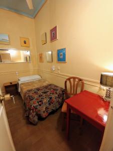 una camera d'albergo con letto, tavolo e sidro. di Hostal La Fontana a Madrid