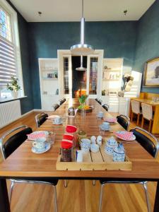 een grote houten tafel met stoelen in een kamer bij B&B Het Voorhuis in Loon op Zand