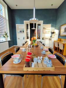a large wooden table with chairs in a room at Familie- en Groepsverblijf Het Voorhuis in Loon op Zand