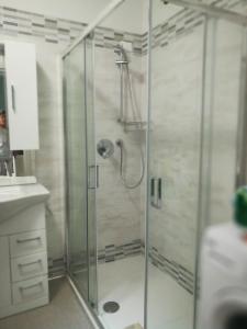 una doccia con porta in vetro in bagno di Attico Open Space - Piscina a 400 mt a Desenzano del Garda
