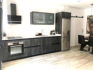 a kitchen with a sink and a refrigerator at EL AGAVE DE MERESE APARTAMENTO in Las Toscas
