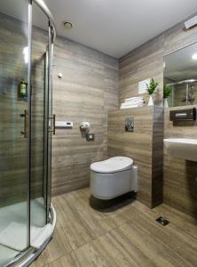 uma casa de banho com um WC, um lavatório e um chuveiro em UPA Medical SPA em Druskininkai