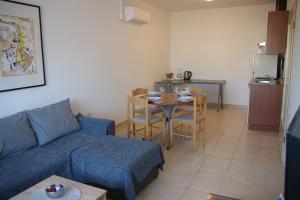 a living room with a couch and a table and a kitchen at APARTMAN ADRIATIC in Pula