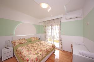 een slaapkamer met een bed en een raam bij Apartments Aleksandra in Podgorica