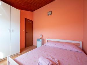 a bedroom with a bed with a pink bedspread at Holiday Home Medica - PZN318 by Interhome in Tinjan