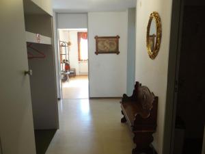einen Flur mit einer Tür, einem Stuhl und einem Spiegel in der Unterkunft Apartment Sunnmatt Süd Wohnung 831 by Interhome in Engelberg