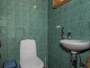 a green tiled bathroom with a toilet and a sink at Holiday Home Ahmanportti 2 by Interhome in Ylläs