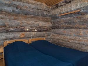 a room with wooden walls and a blue couch at Holiday Home Ahmanportti 2 by Interhome in Ylläs +22 photos