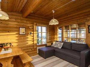 una sala de estar con sofá en una cabaña de madera en Holiday Home Huvilakoti 2 by Interhome, en Puromäki