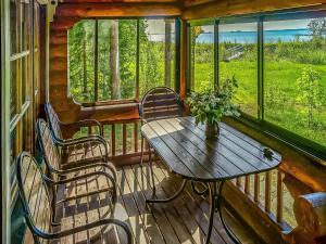 eine Holzterrasse mit einem Holztisch und 2 Stühlen in der Unterkunft Holiday Home Huvilakoti 2 by Interhome in Puromäki