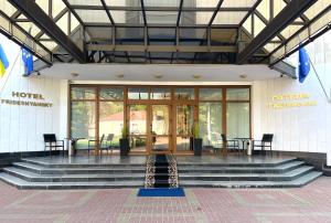 a lobby of a hotel with stairs and a table and chairs at Hotel Prydesnyansky in Chernihiv