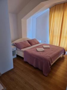 a bedroom with a bed with two towels on it at Apartmani Selektor in Bijelo Polje