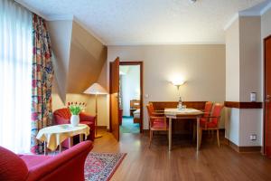 a living room with a table and chairs at Aparthotel Hohenzollern in Bad Kissingen