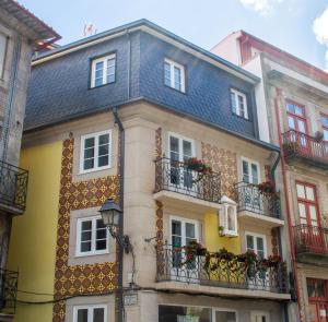 a yellow building with balconies and a blue roof at BF Suites & Apartments in Porto