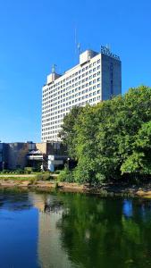 un grande edificio accanto a un corpo idrico di Hotel Gromada Pila a Piła