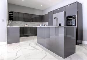 a kitchen with stainless steel appliances and black cabinets at Beautiful modern open plan living with Hot Tub in Kelty