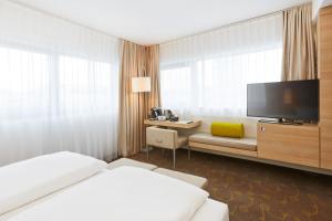 Ein Bett oder Betten in einem Zimmer der Unterkunft H+ Hotel Salzburg
