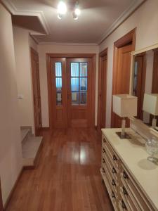 a bathroom with a sink and a mirror and wood floors at Casa San Miguel in Huércanos