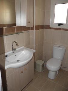 een badkamer met een wastafel en een toilet en een raam bij St. Lazaros House in Larnaka +12 foto's