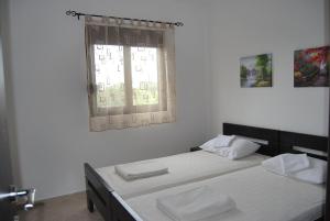 1 dormitorio con 2 camas y ventana en Apartments Aneta, en Ulcinj