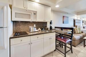a kitchen with a stove top oven and a sink at Best Western Plus Beach Resort in Fort Myers Beach