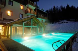 a swimming pool in the snow at night at Résidence Les Alpages 4 étoiles - Appartement 4 personnes - Piscine, Hammam, Sauna, Jacuzzi - ValCenis 73480 in Lanslebourg-Mont-Cenis