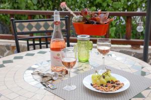 - une table avec une bouteille de vin et une assiette de fruits dans l'établissement Los Geranios, Close to BEACH, Puerto Colon, YellowCat 2, à Adeje