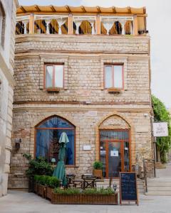 een bakstenen gebouw met een balkon erboven bij Maajid Hotel & Restaurant in Baku