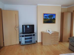 un soggiorno con TV su un armadio e una porta di Appartements Edda a Strobl