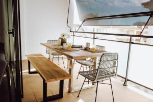 een tafel en stoelen in een kamer met een balkon bij Hauzify I Apartaments Coral in Torredembarra