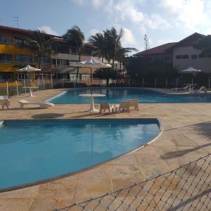 une grande piscine avec des chaises et des parasols dans l'établissement Frente a Praia Aconchegante, à Fortaleza