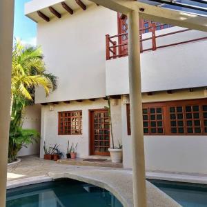 a house with a swimming pool in front of it at Bed and Breakfast Pecarí in Cancún