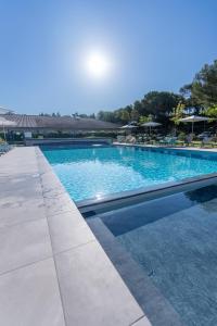 une grande piscine d'eau bleue dans l'établissement Kyriad Résidence Cabriès - Plan de Campagne, à Cabriès