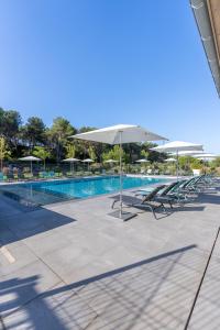 a swimming pool with chairs and umbrellas next to a pool at Kyriad Résidence Cabriès - Plan de Campagne in Cabriès