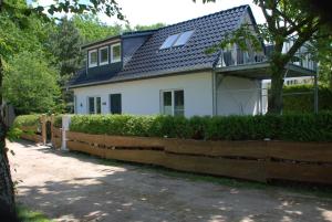 uma casa branca com uma cerca de madeira em frente em Ferienhaus Sonnenschein em Insel Poel