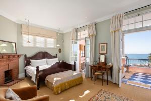 a bedroom with a bed and a fireplace and a balcony at Majestic Ocean View Retreat in Cape Town