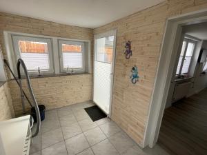 a bathroom with a brick wall with windows and a shower at Ferienapartment Stemmert in Gelting
