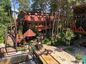 una gran casa en el bosque con un parque infantil en Hotel Barbizon, en Nyíregyháza