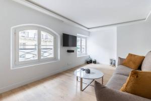 uma sala de estar com um sofá e uma mesa em HSH Invalides-Palais Bourbon Luxueux Appartement 4P em Paris