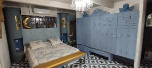 1 dormitorio con taquillas azules y 1 cama. en Domaine Le Lanis Chambre d'hôtes piscine spa en Saint-Girons