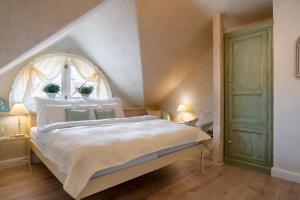 1 dormitorio con 1 cama blanca grande y ventana en Boutique hotel Soukeníkův dům en Kutná Hora