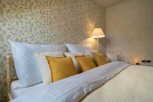 1 cama grande con almohadas amarillas y blancas en Boutique hotel Soukeníkův dům, en Kutná Hora