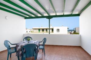 eine Terrasse mit einem Tisch und Stühlen auf dem Balkon in der Unterkunft La Bonanza in Playa Blanca