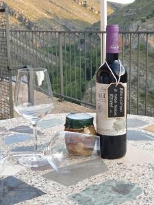 een fles wijn en een glas op een tafel bij Casa Rural Reyes in Nuévalos