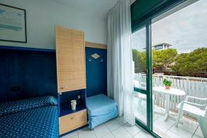 リド・ディ・イエゾロにあるHotel Olandaのベッドルーム(ベッド1台付)、バルコニーが備わります。