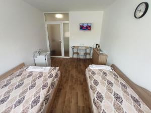 a room with two beds and a table in it at Top Center Nice View Studio in Gabrovo