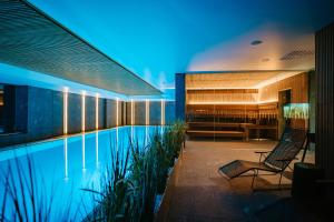 a hotel swimming pool with two chairs and a bar at Hestia Hotel Haapsalu SPA in Haapsalu