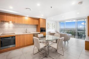a kitchen with a table and chairs and a dining room at Chevron Renaissance 2 Bed Apartment by Vaun in Gold Coast