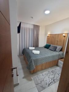 ein Schlafzimmer mit einem Bett mit einem Kopfteil aus Holz in der Unterkunft Apartman Zlatibor Philautia in Zlatibor